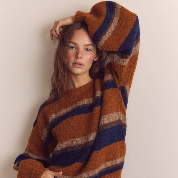 Woman wearing a striped sweater with a neutral background