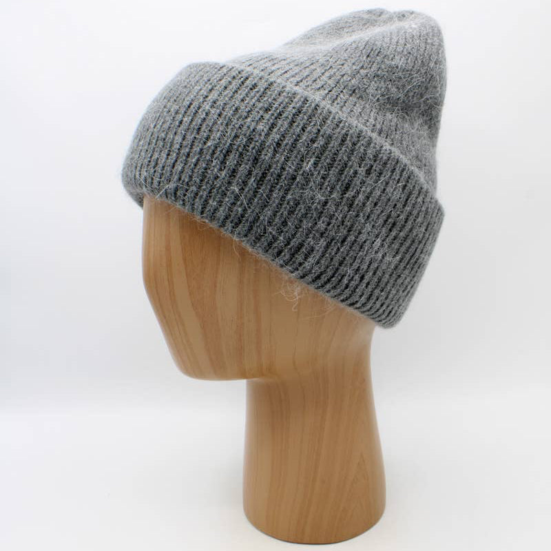 Gray knit beanie on a wooden mannequin head against a white background